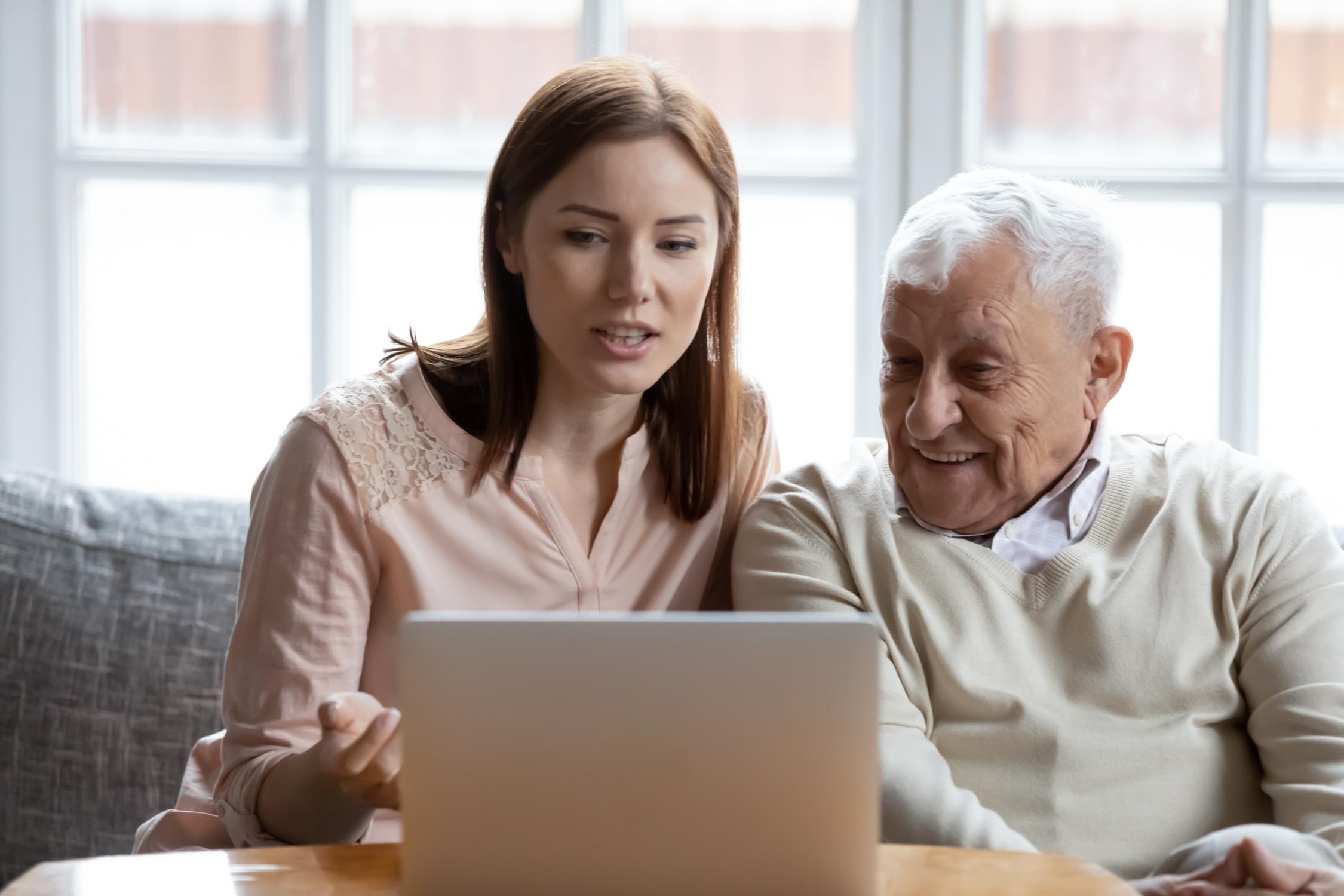 Alter Mann und junge Frau am Laptop